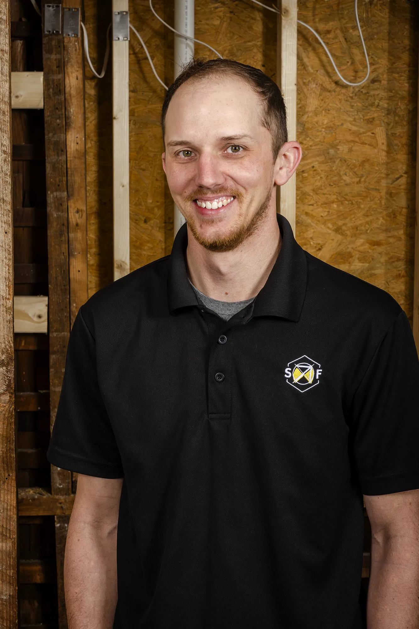 Preston Harris, founder of Solid Foundation Construction, standing in a framed-out room